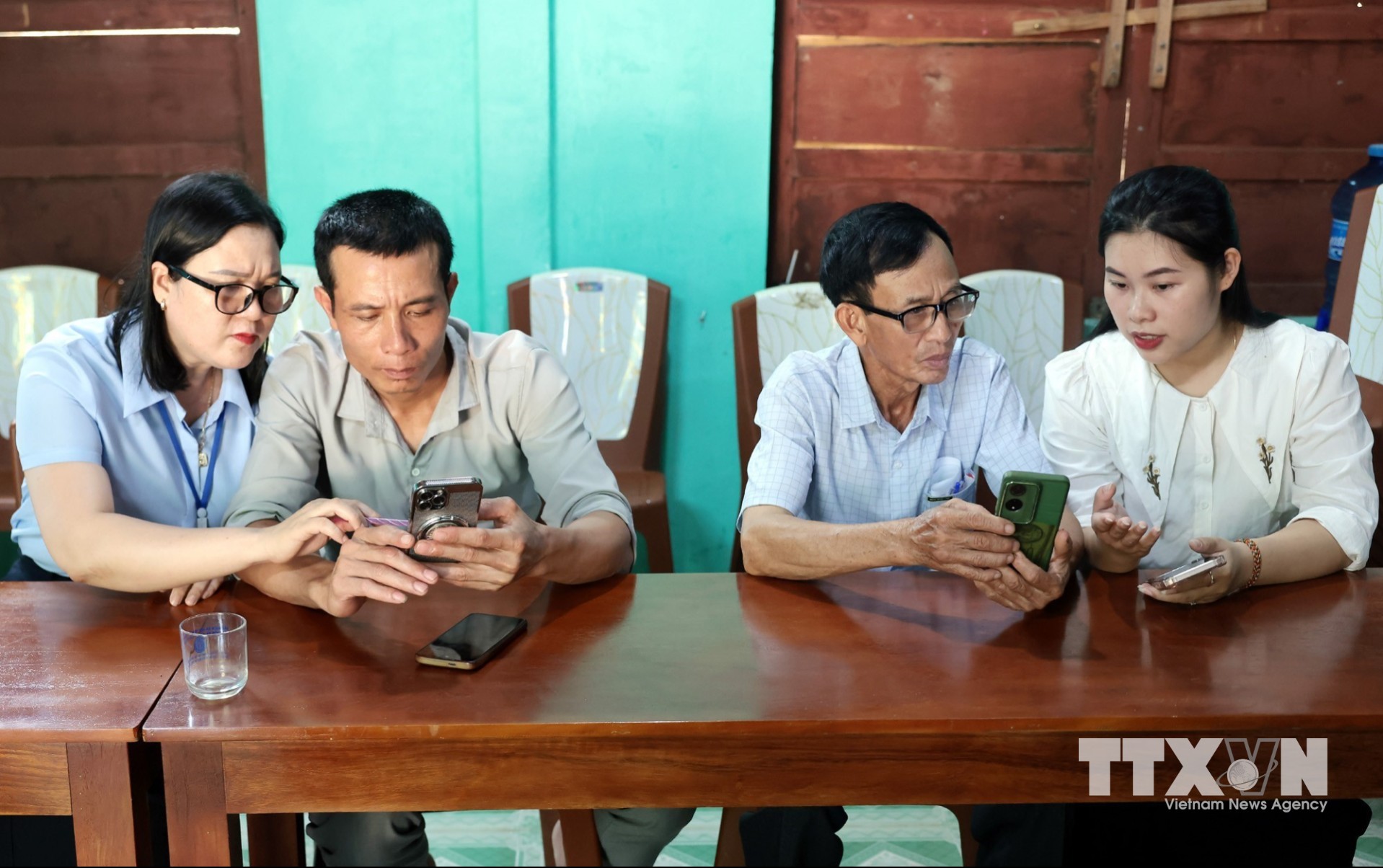 Trợ giúp người dân cài đặt, khai thác, sử dụng thông tin trên ứng dụng Quangtri - S và các ứng dụng khác. (Ảnh: Trần Việt/TTXVN)